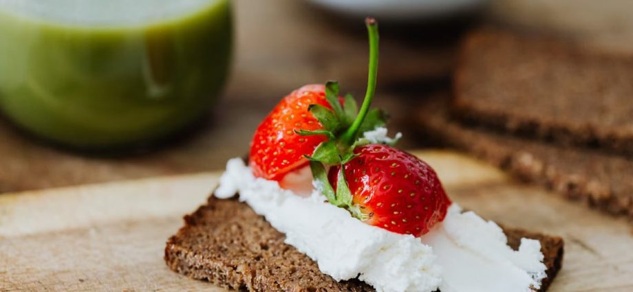 Rye bread topped with cream and juicy strawberries, perfect for a sweet treat.